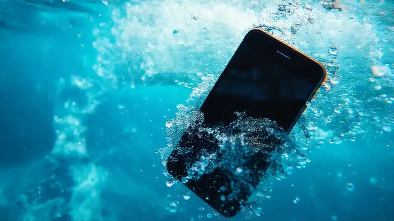 Un iPhone vibrante flota en agua turbulenta
