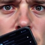 Cara preocupada frente a un iPhone
